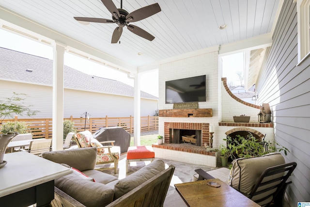 view of patio with fence, an outdoor living space with a fireplace, and ceiling fan