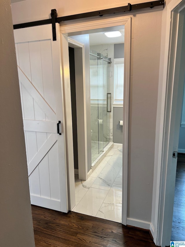full bath featuring baseboards, a shower stall, and wood finished floors