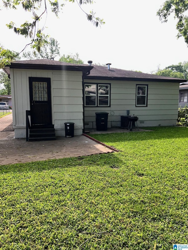 back of property featuring a lawn, a patio, and entry steps