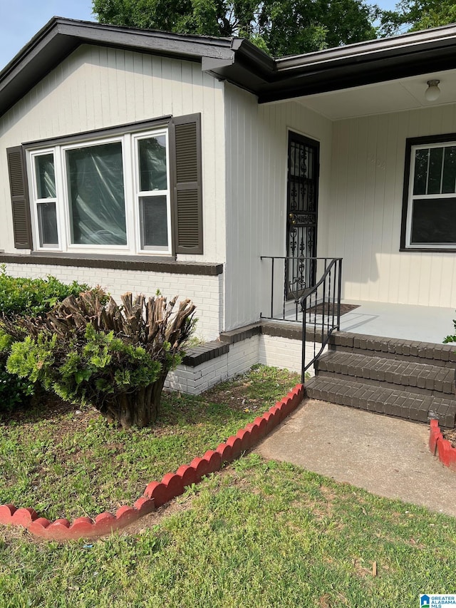 entrance to property featuring brick siding and a porch