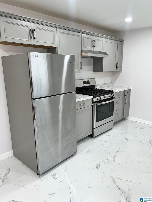 kitchen with appliances with stainless steel finishes, gray cabinets, baseboards, and marble finish floor