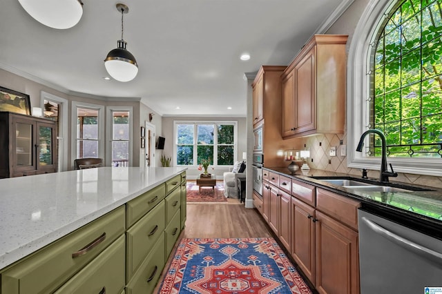 kitchen featuring a sink, green cabinetry, light wood-type flooring, crown molding, and appliances with stainless steel finishes