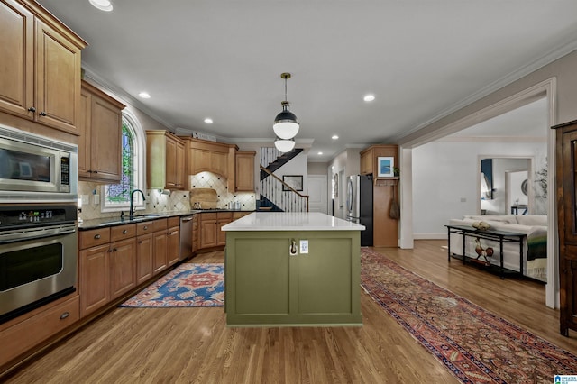 kitchen featuring a sink, ornamental molding, and stainless steel appliances