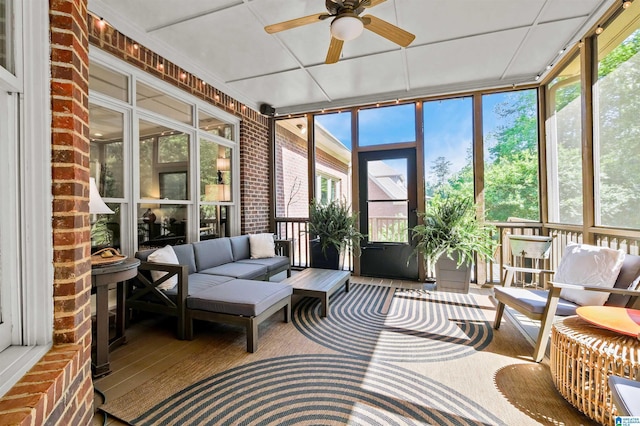 sunroom / solarium featuring an outdoor living space, a ceiling fan, and a healthy amount of sunlight