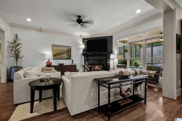 living room with wood finished floors, recessed lighting, crown molding, ceiling fan, and a lit fireplace