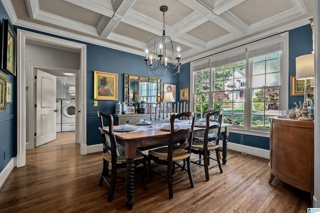 dining area with a chandelier, wood finished floors, baseboards, and washer and dryer