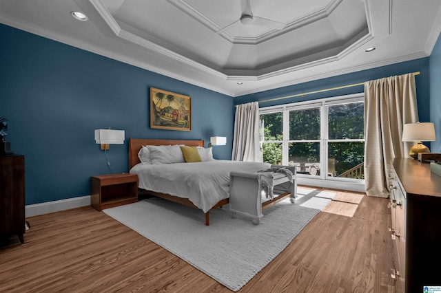 bedroom featuring recessed lighting, baseboards, ornamental molding, wood finished floors, and a raised ceiling