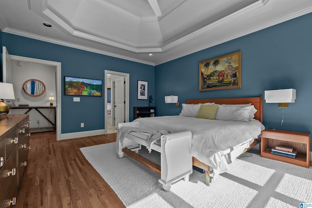 bedroom featuring a tray ceiling, dark wood-style flooring, baseboards, and ornamental molding