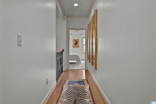 corridor featuring baseboards, light wood-style floors, and an upstairs landing