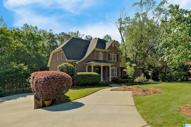 view of front of house with a front lawn and brick siding
