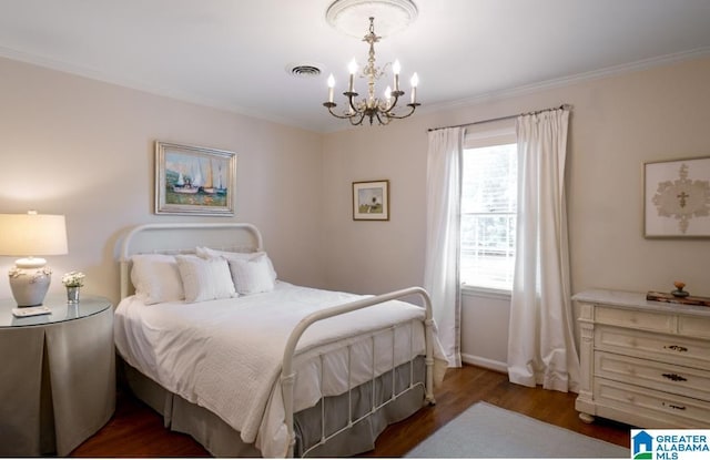 bedroom featuring a notable chandelier, crown molding, visible vents, and wood finished floors