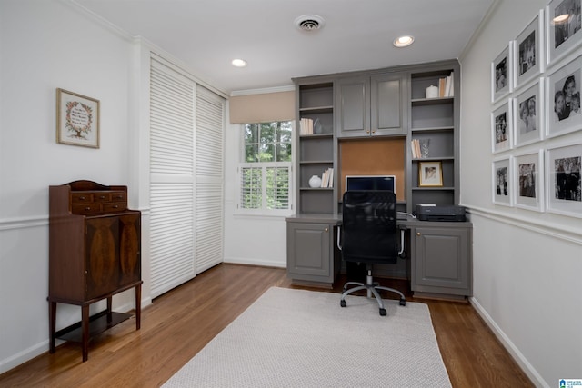 office area featuring baseboards, crown molding, visible vents, and wood finished floors
