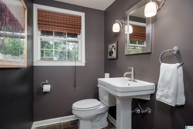 half bathroom with toilet and baseboards