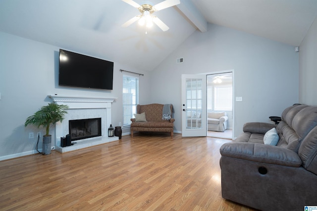 living room with ceiling fan, beam ceiling, plenty of natural light, light wood-type flooring, and visible vents