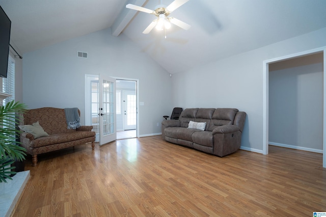 living area with visible vents, beamed ceiling, high vaulted ceiling, a ceiling fan, and light wood-style flooring