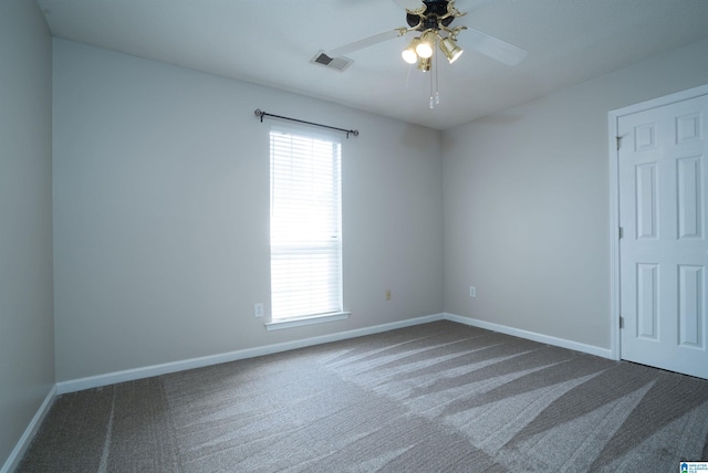 unfurnished room featuring dark colored carpet, baseboards, ceiling fan, and visible vents