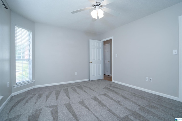 empty room with baseboards, carpet, and a ceiling fan