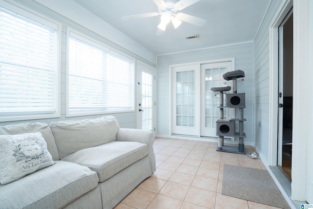 living area featuring light tile patterned flooring, ceiling fan, and visible vents