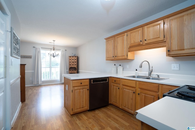 kitchen featuring a notable chandelier, a sink, light wood finished floors, a peninsula, and black appliances