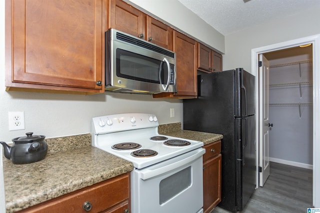 708 Patton Chapel Way Unit 708, Hoover, AL 35226 - kitchen with white electric stove, brown cabinets, wood finished floors, stainless steel microwave, and freestanding refrigerator