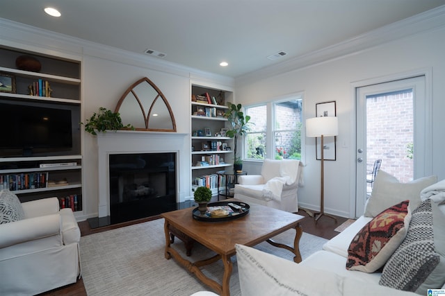 living room with crown molding, wood finished floors, and visible vents