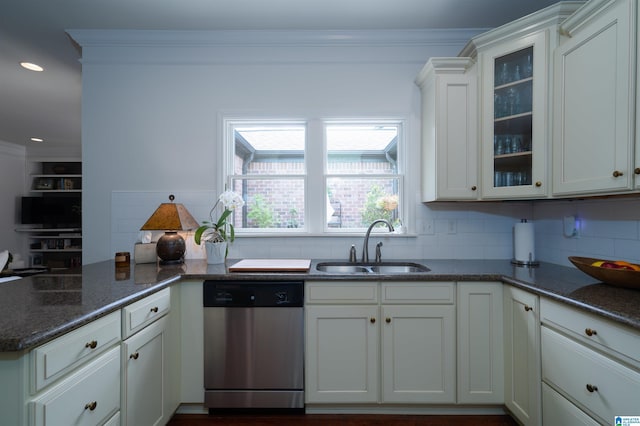 kitchen with stainless steel dishwasher, a sink, decorative backsplash, and a peninsula