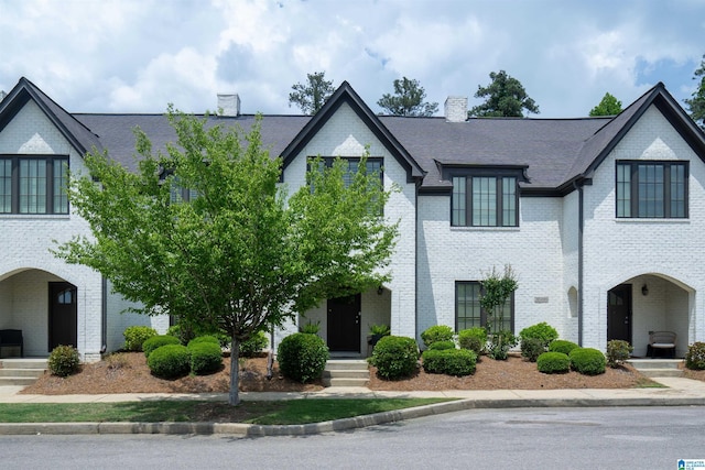 view of front of property with a chimney and brick siding