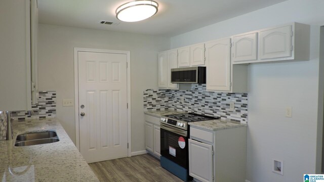 316 Creek Run Cir, Calera, AL 35040 - kitchen with appliances with stainless steel finishes, a sink, tasteful backsplash, wood finished floors, and white cabinets