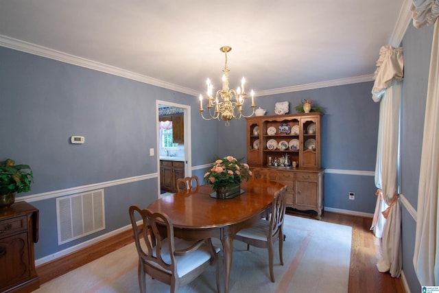 836 Tulip Poplar Dr, Hoover, AL 35244 - dining room featuring light wood-type flooring, a chandelier, crown molding, and baseboards