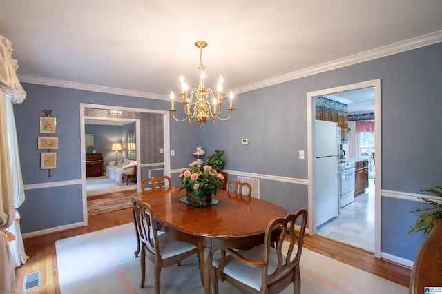836 Tulip Poplar Dr, Hoover, AL 35244 - dining room with a chandelier, light wood finished floors, crown molding, and baseboards