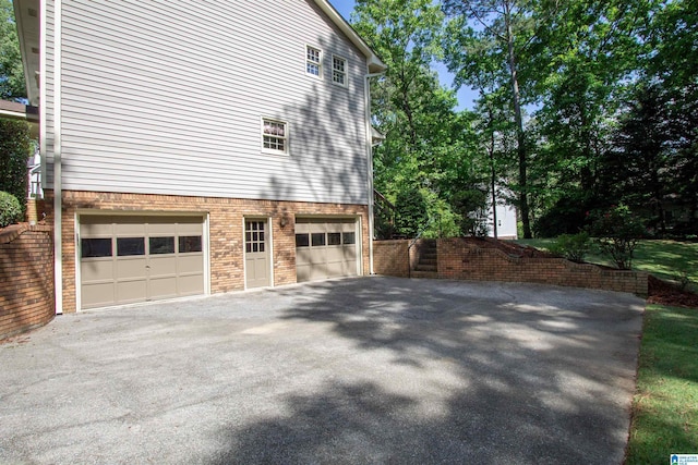 836 Tulip Poplar Dr, Hoover, AL 35244 - view of side of home with an attached garage, asphalt driveway, and brick siding