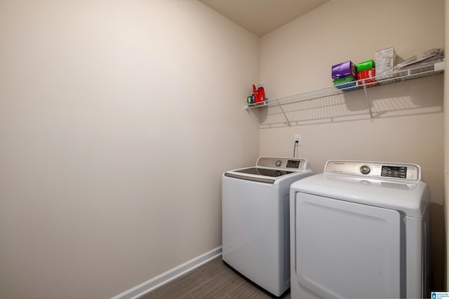 washroom with laundry area, baseboards, and separate washer and dryer