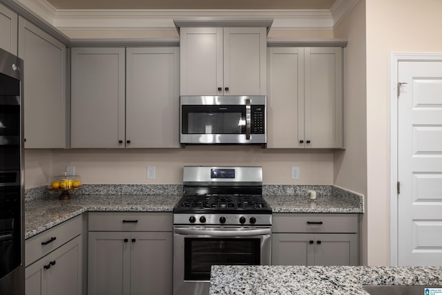 kitchen featuring appliances with stainless steel finishes, gray cabinets, ornamental molding, and light stone counters