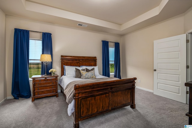 bedroom featuring a raised ceiling, baseboards, carpet flooring, and visible vents