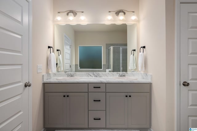 bathroom with double vanity, a sink, and a stall shower
