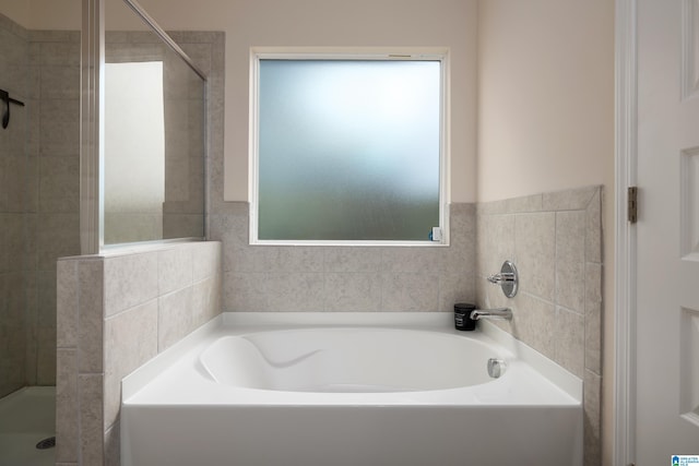 full bathroom with a bath and tiled shower