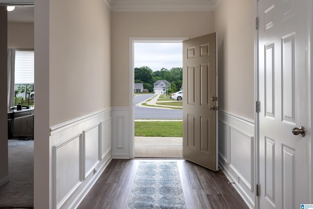 entryway with ornamental molding, wainscoting, dark wood-style flooring, and a decorative wall