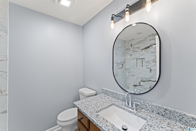 bathroom featuring toilet, walk in shower, and vanity