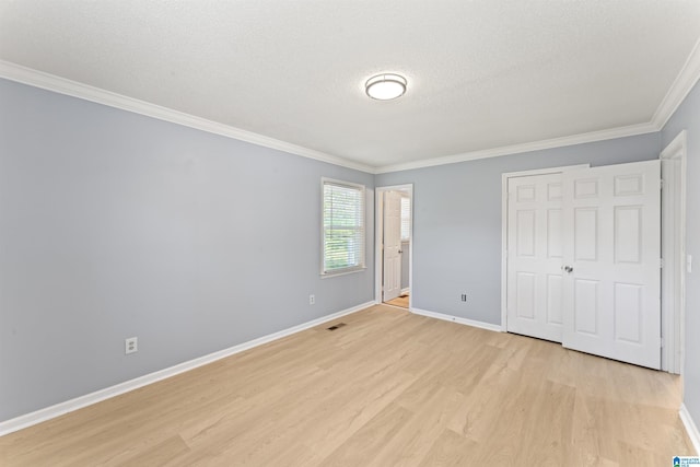 unfurnished bedroom with crown molding, baseboards, visible vents, and light wood-style floors