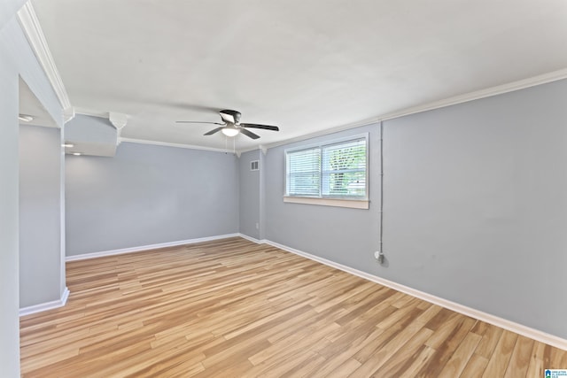 spare room featuring crown molding, baseboards, ceiling fan, and light wood-style floors