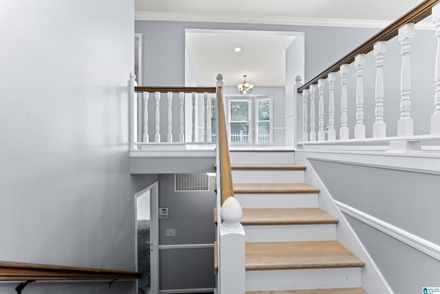 staircase featuring crown molding, a notable chandelier, and visible vents