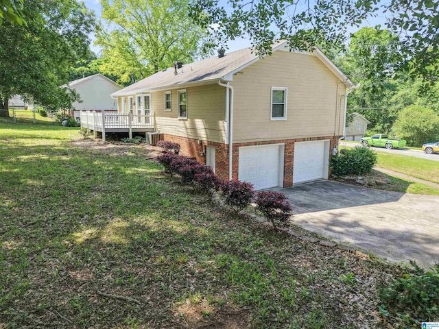 view of side of home with a lawn, a garage, central AC, and concrete driveway