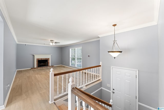 staircase featuring baseboards, ceiling fan, ornamental molding, and wood finished floors