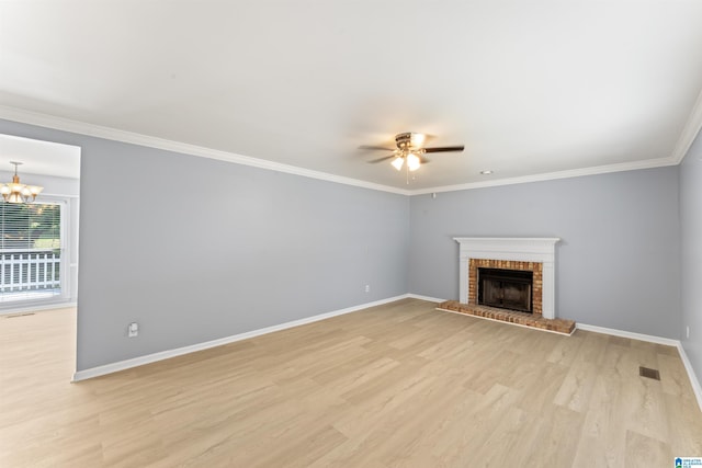 unfurnished living room with visible vents, a brick fireplace, baseboards, light wood-type flooring, and ceiling fan with notable chandelier