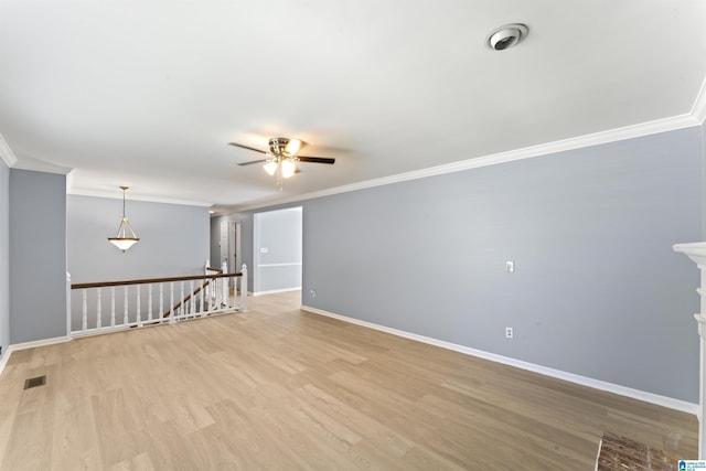 empty room featuring baseboards, a ceiling fan, light wood finished floors, and ornamental molding