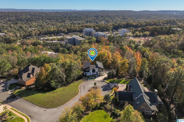 aerial view of property and surrounding area featuring a heavily wooded area