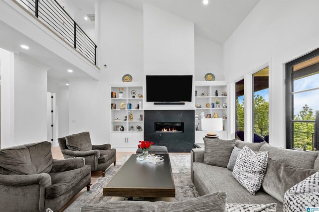 living area with high vaulted ceiling, a high end fireplace, and recessed lighting