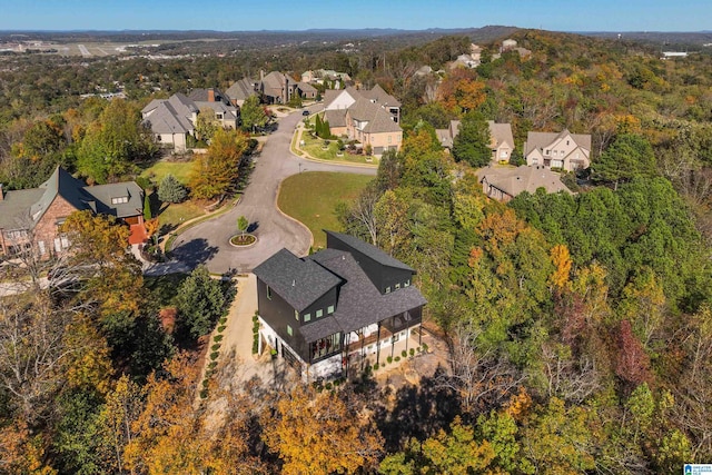aerial overview of property's location featuring nearby suburban area and a forest