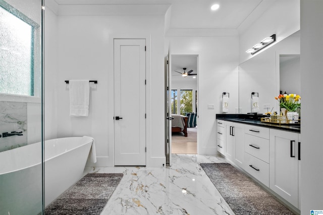 full bath featuring ensuite bathroom, marble tiled floors, ceiling fan, vanity, and a freestanding tub