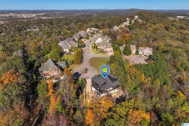 aerial overview of property's location with a heavily wooded area and nearby suburban area